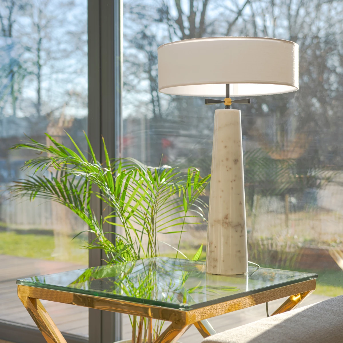 Lampa stołowa BOW z marmurową kolumną, czarną kokardą i białym abażurem przy oknie